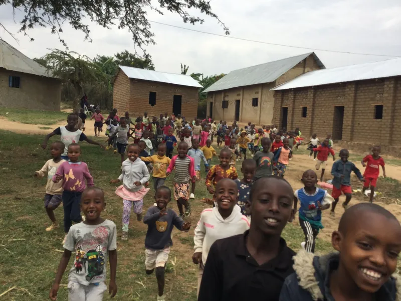 Children running toward the camera between school buildings