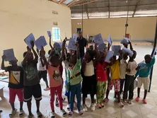 Students holding up exercise books in a classroom