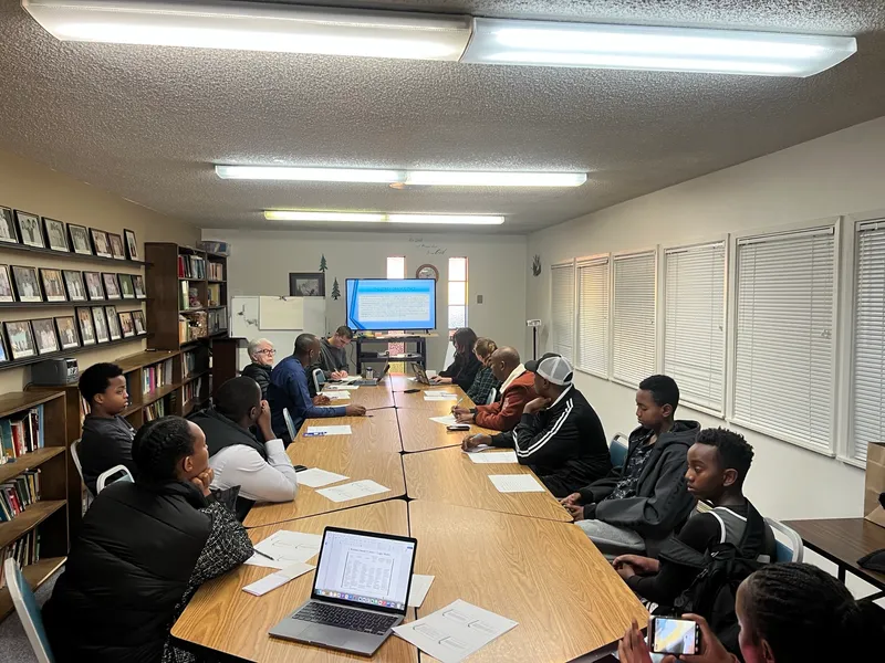 Adults discussing a presentation around a meeting table